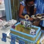 Woman Lights Firework Candle On Birthday Cake For Goat